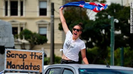 A protester waves a flag from behind a car in Wellington on Tuesday.