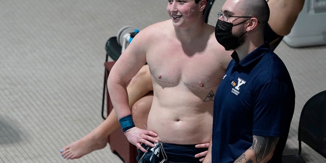 Yale Isaac Hennig smiles as he talks to a coach before the team relay events at the Ivy League Women's Swimming and Diving Championships at Harvard University, Wednesday, Feb. 16, 2022, in Cambridge, Massachusetts.