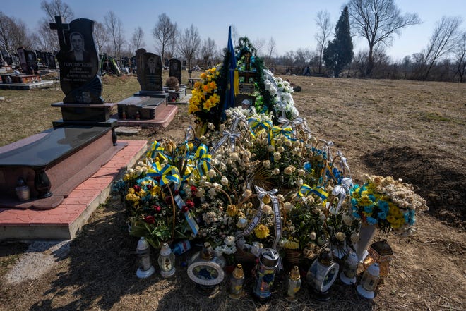 The grave of 25-year-old soldier Roman Pavlovich, who was killed near the besieged city of Mariupol in a cemetery in the village of Hordinia, western Ukraine.