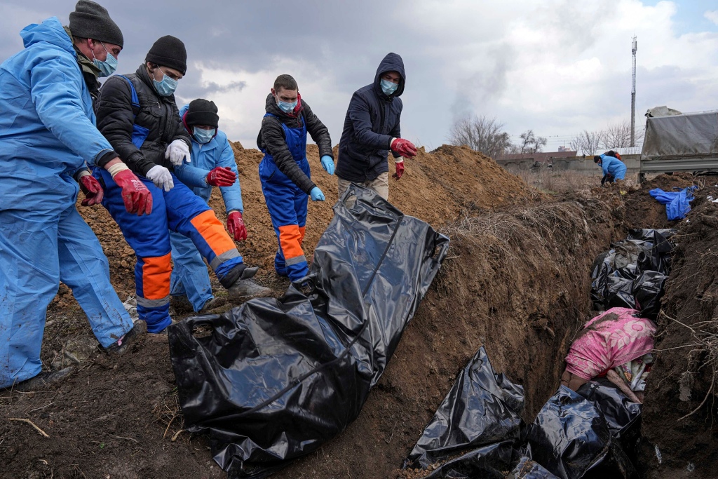Bodies are placed in a mass grave on the outskirts of Mariupol, Ukraine, Wednesday, March 9.