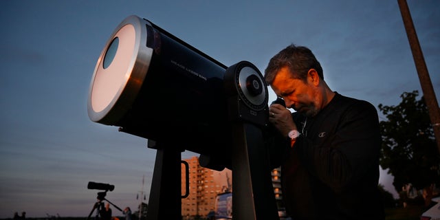 Robert Burgess, chief astronomer for southern Maine, sets up a telescope with solar filters to watch a partial eclipse from the East Party in Portland on Thursday, June 10, 2021.